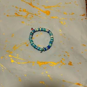 This is a small bracelet for kids it is a blue and white clay beaded bracelet
